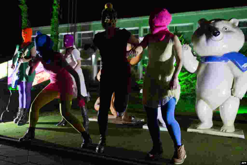 Pussy Riot members in balaclavas perform in front of Sochi 2014 Winter Olympic Games mascots as they record a video in the Adler district of Sochi early on February 18. (epa/Yevgeny Feldman)