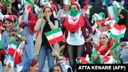 Iranian women cheer ahead of the World Cup Qatar 2022 Group C qualification football match between Iran and Cambodia at the Azadi stadium in the capital Tehran on October 10, 2019.