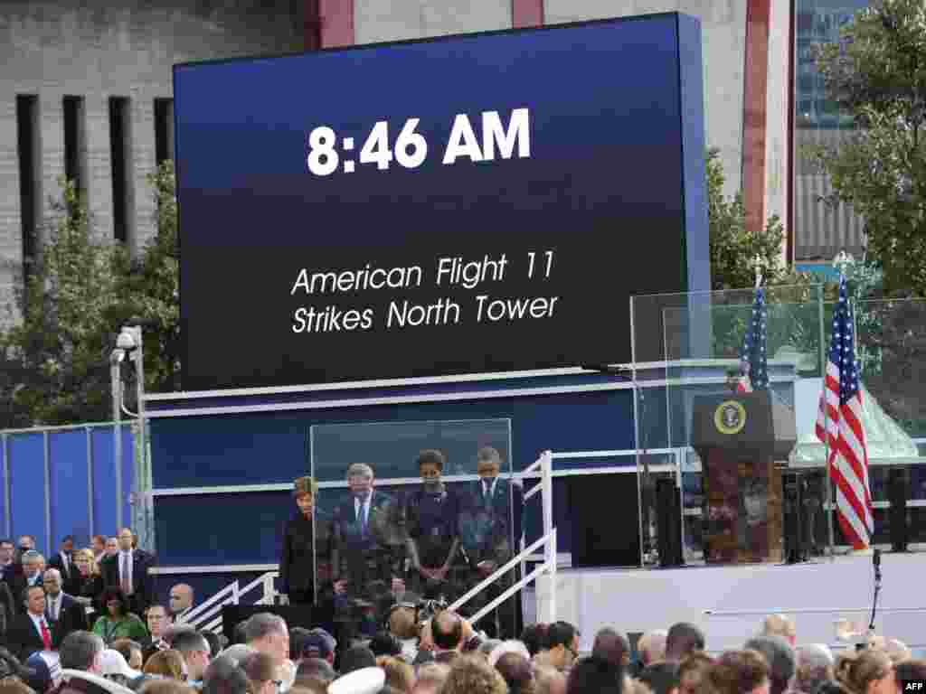 President Barack Obama, his wife Michelle Obama, ex-President George W. Bush, and his wife Laura Bush observe a moment of silence at the time the first hijacked airliner crashed into the North Tower in 2001.