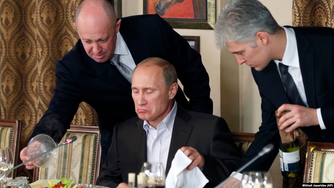 Businessman Yevgeny Prigozhin (left) serves food to then-Russian Prime Minister Vladimir Putin in 2011.