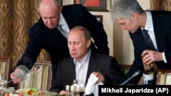 Vladimir Putin servit personal de magnatul Evgheni Prigojin (stânga), fondatorul companiei de mercenari «Wagner», în restaurantul acestuia din afara Moscovei, 11 noiembrie 2011