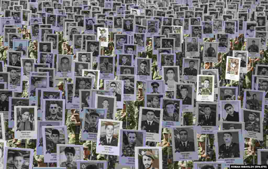 Азербайджанские солдаты несут портреты военнослужащих и гражданских лиц, погибших во время второй карабахской войны. Памятный марш в центре Баку прошел 27 сентября 2021 года, в годовщину начала войны&nbsp;