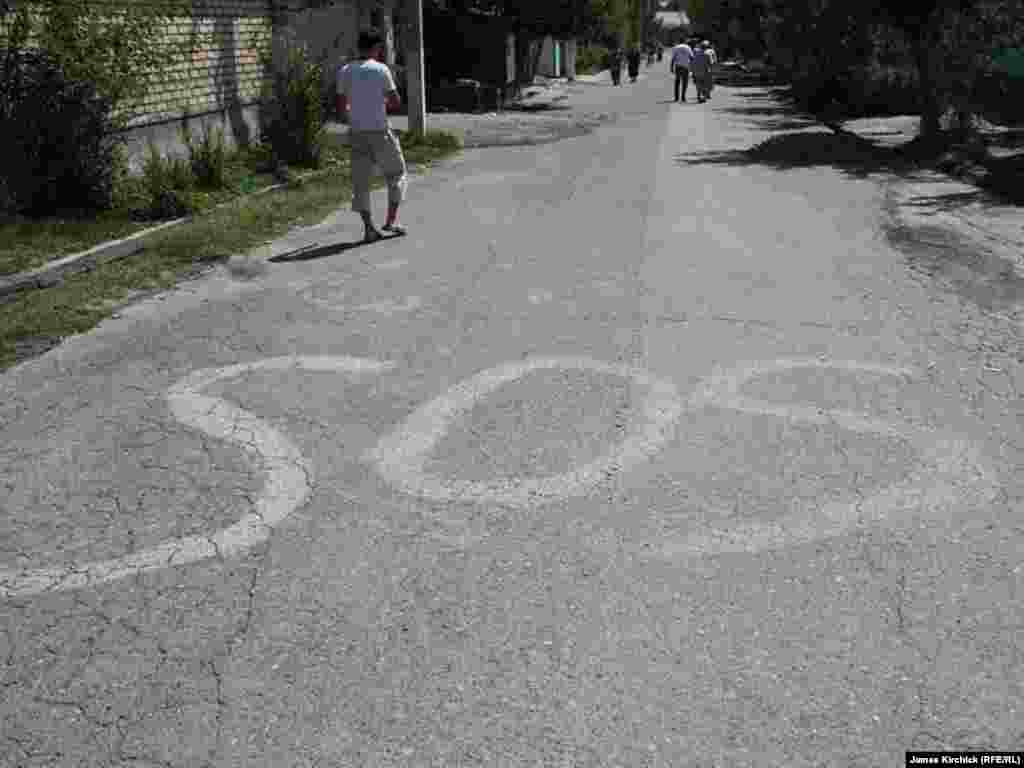Ўшнинг ўзбек маҳаллаларидан бири йўлидаги ëзув.