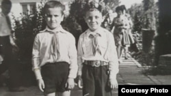 Gabriel Petrescu, băiatul cu coroniță de premiul I, alături de colegul său, Sebi. Împreună au fost cât pe-aci să o pățească fiindcă s-au lăudat în fața unui profesor că ascultă „Europa Liberă” și „Vocea Americii”, adică posturi de radio finanțate de inamicul american.