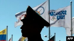 Russia -- An Honor Guardsman stands in front of the flags during the US team welcome ceremony in Sochi, February 6, 2014