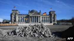 Un steag ucrainean flutură pe Bundestag, la Berlin, pe 24 februarie. În privința războiului declanșat de Rusia împotriva Ucrainei, ideile câștigătorilor alegerilor germane diferă mult de ale lui Donald Trump. 