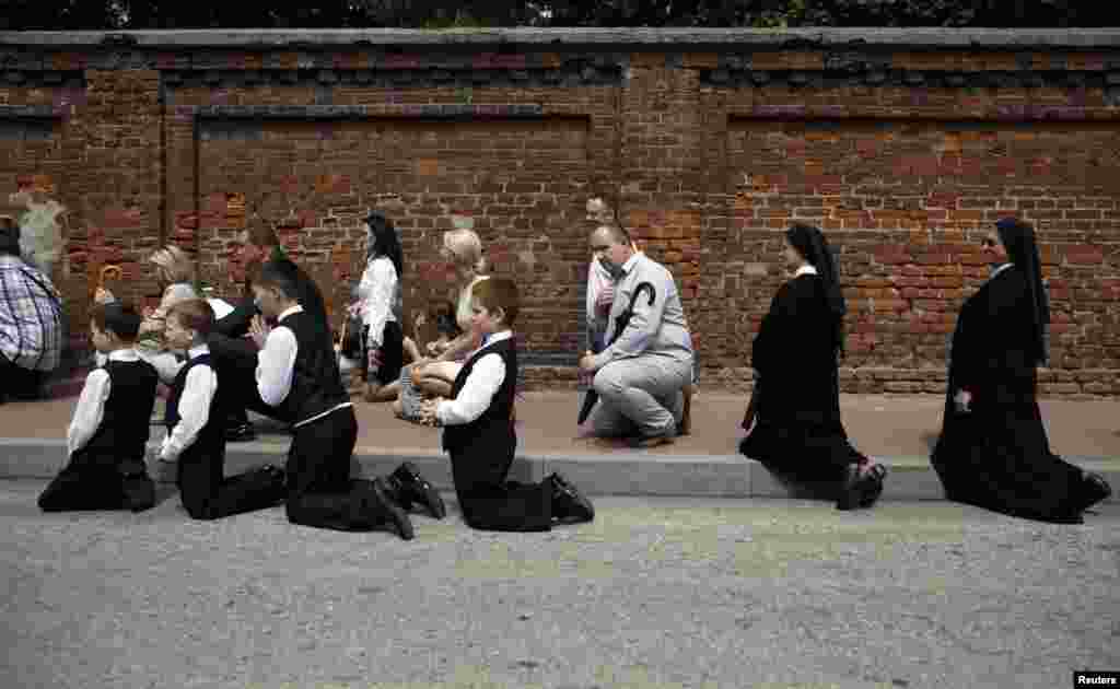 People kneel on the street as they take part in a Corpus Christi procession in Gora Kalwaria near Warsaw, Poland. (Reuters/Kacper Pempel)