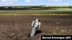 Неразорвавшийся снаряд в поле в Донецке, июнь 2022