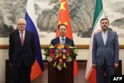 Russian Deputy Foreign Minister Sergei Ryabkov, Chinese Executive Vice Minister of Foreign Affairs Ma Zhaoxu, and Iranian Deputy Foreign Minister Kazem Gharibabadi pose after a meeting in Beijing on March 14.