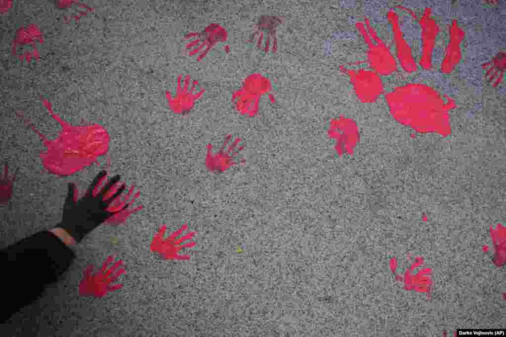 People with red paint on their hands, symbolizing blood, leave imprints on the pavement during a protest about the collapse of a concrete canopy at the railway station in the Serbian city of Novi Sad, which killed 15 people last month.&nbsp;