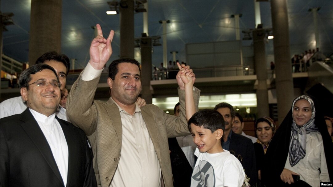 Shahram Amiri flashes the victory sign as he arrives at the Imam Khomeini Airport in Tehran.