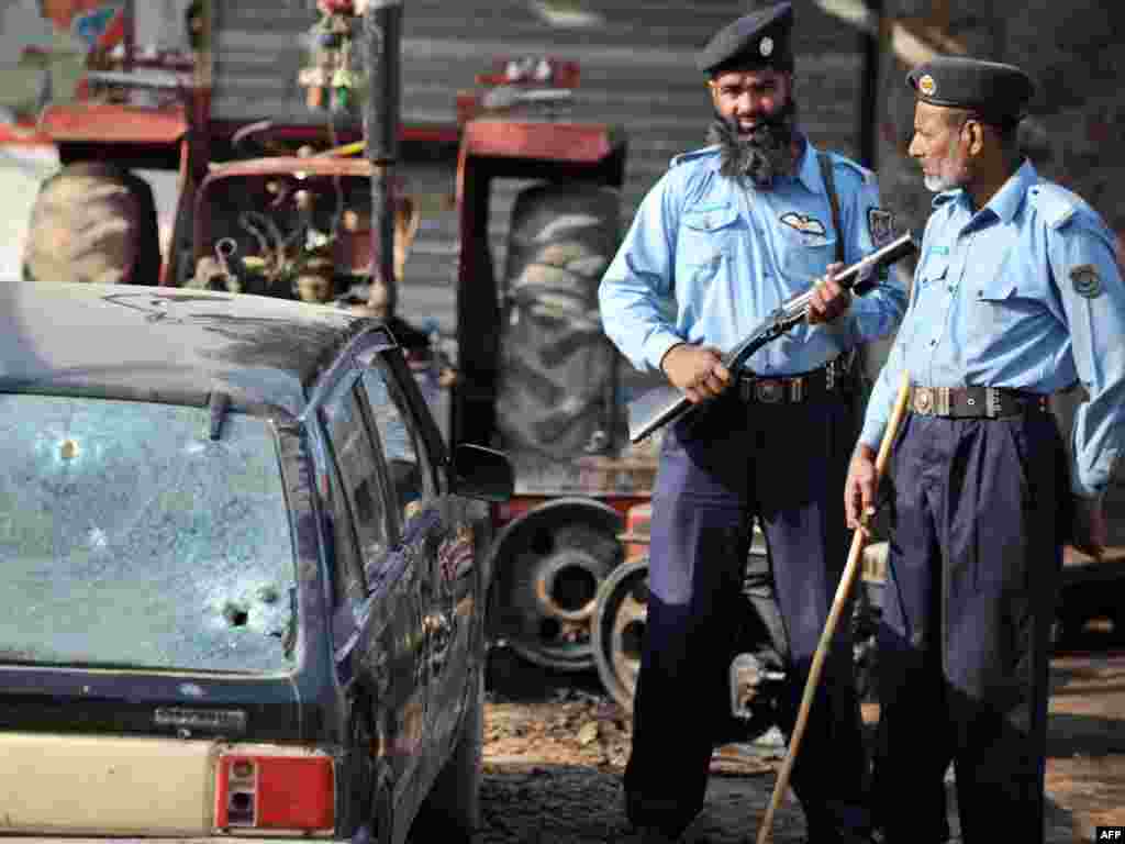 Pakistan -- Policemen stand at the site of a shooting in Islamabad, 22Oct2009 - PAKISTAN, Islamabad : Pakistani policemen stand at the site of a shooting in Islamabad on October 22, 2009. Gunmen riding a motorbike ambushed a military jeep in Pakistan's capital, unleashing a hail of bullets that killed a brigadier and his driver in a brazen daylight raid, officials said.