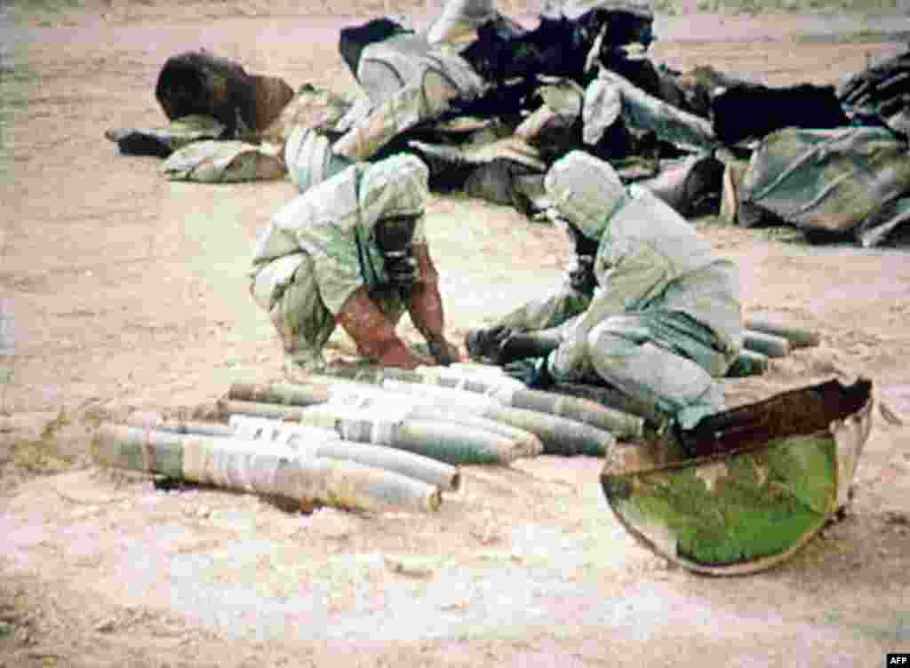Members of a UN chemical weapons team readies some 1,000 liters of mustard gas for a controlled explosion on November 24, 1992, in Al-Muthanna, Iraq. (Iraqi television)