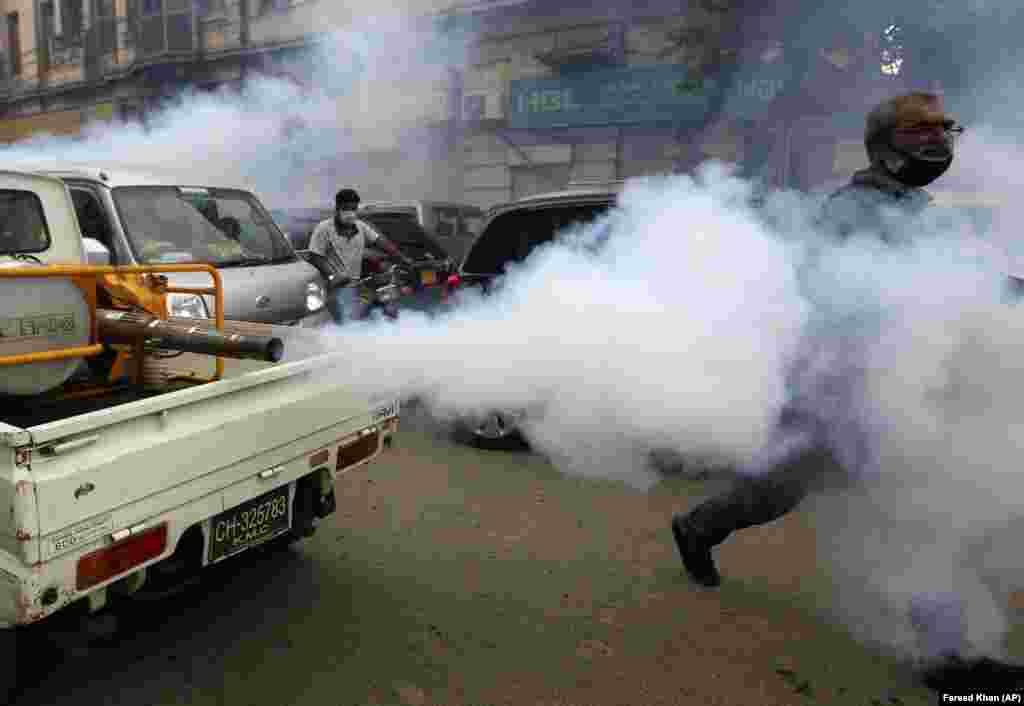 Пакистанские добровольцы распыляют дезинфицирующее средство на рынке в Карачи, пытаясь сдержать рост числа случаев коронавируса