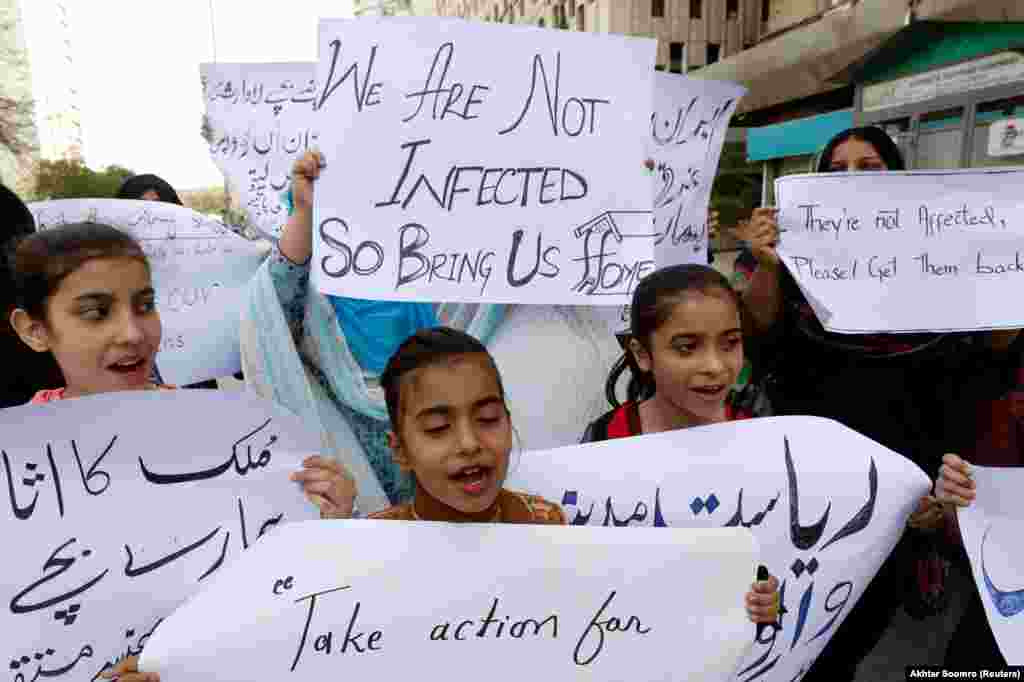 Члены семьи в Карачи (Пакистан) держат знаки с требованием эвакуировать пакистанских студентов из Китая. Они не смогли вернуться после вспышки коронавируса
