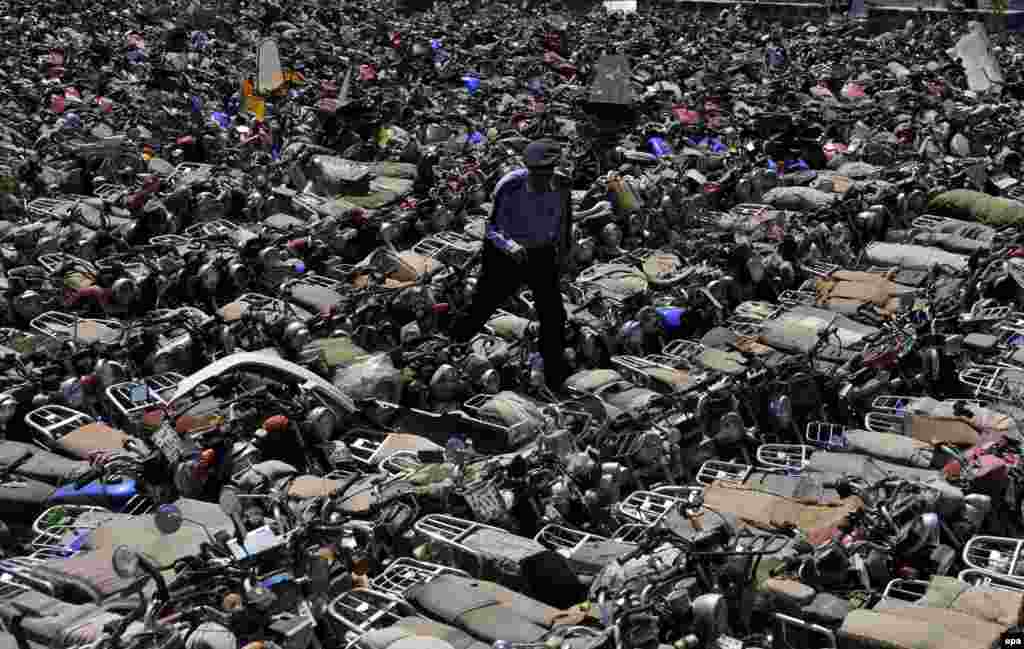 A Yemeni police officer inspects hundreds of seized motorbikes at a police yard in Sanaa. Reports state that Yemeni authorities resumed enforcing a ban on motorbikes used as taxis in Sanaa to prevent Al-Qaeda-linked attacks by motorcyclists on the country&#39;s military and security personnel and members of the Shi&#39;ite Houthi movement. (epa/Yahya Arhab) 