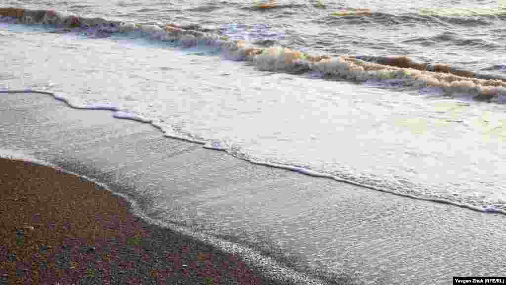 Морские волны продолжают подмывать глинистый берег, оставляя гальку на пляже