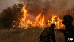 Echipajele de urgență din Grecia încearcă să stingă un incendiu de vegetație. 12 august 2024. Autoritățile de protecție civilă din Grecia au ordonat evacuarea mai multor localități din suburbiile Atenei.