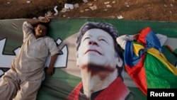 Supporters of Imran Khan, the Chairman of the Pakistan Tehreek-e-Insaf (PTI) political party, take a nap on Khan's campaign banner during what has been dubbed a "freedom march" in Islamabad August 25, 2014.