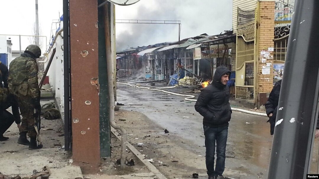 People stand near a burnt market in the Chechen capital, Grozny, in the aftermath of the fighting.