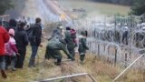 A picture taken on November 8, 2021 shows Poland's law enforcement officers blocking migrants at the Belarusian-Polish border. - Poland on November 8 said hundreds of migrants in Belarus were descending on its border aiming to force their way into the EU 