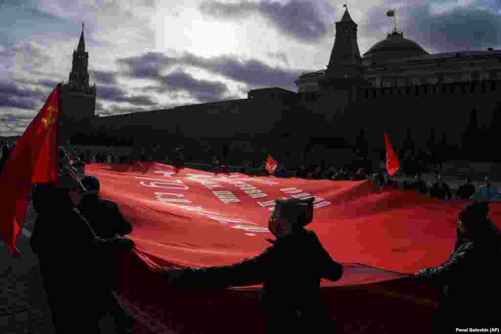 Communist Party supporters hold a huge red flag as they walk toward the Tomb of Soviet founder Vladimir Lenin during a demonstration marking the 104th anniversary of the 1917 Bolshevik Revolution in Moscow&#39;s Red Square on November 7.