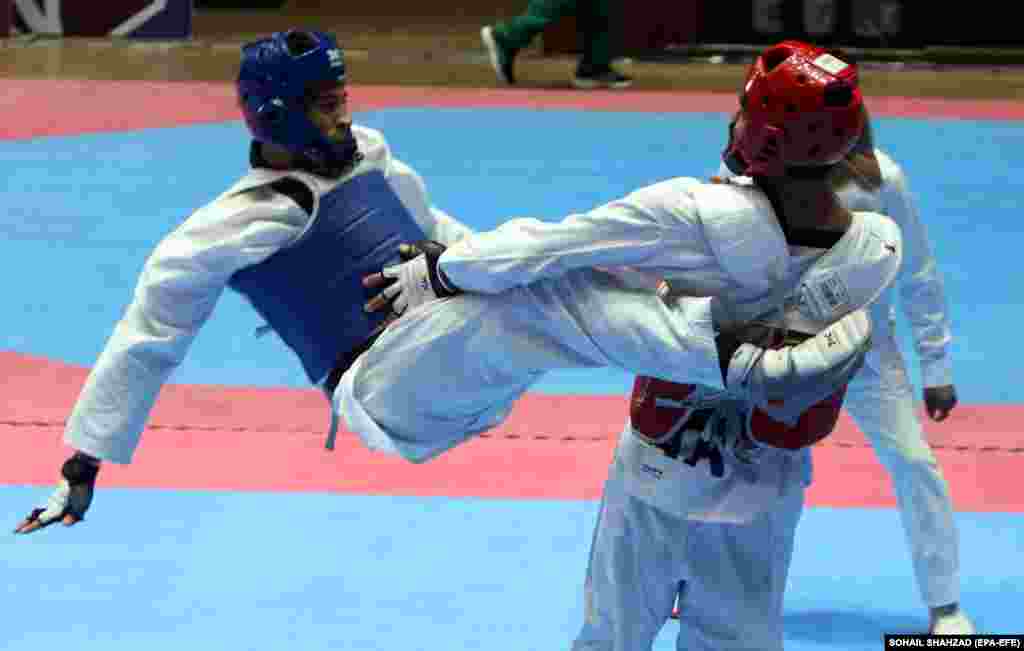 Afghanistan&#39;s Ramesh Hussaini (blue) takes flight in action against Pakistani Adil (red) during the men&#39;s Taekwondo International Championship in Islamabad on November 8.
