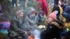 BELARUS - NOVEMBER 8, 2021: Migrants sit by a bonfire on the Belarusian-Polish border. Nearly 1,000 refugees were heading towards the Polish border in the morning of November 8, 2021. The foreigners intend to exercise their right to apply for a refugee st