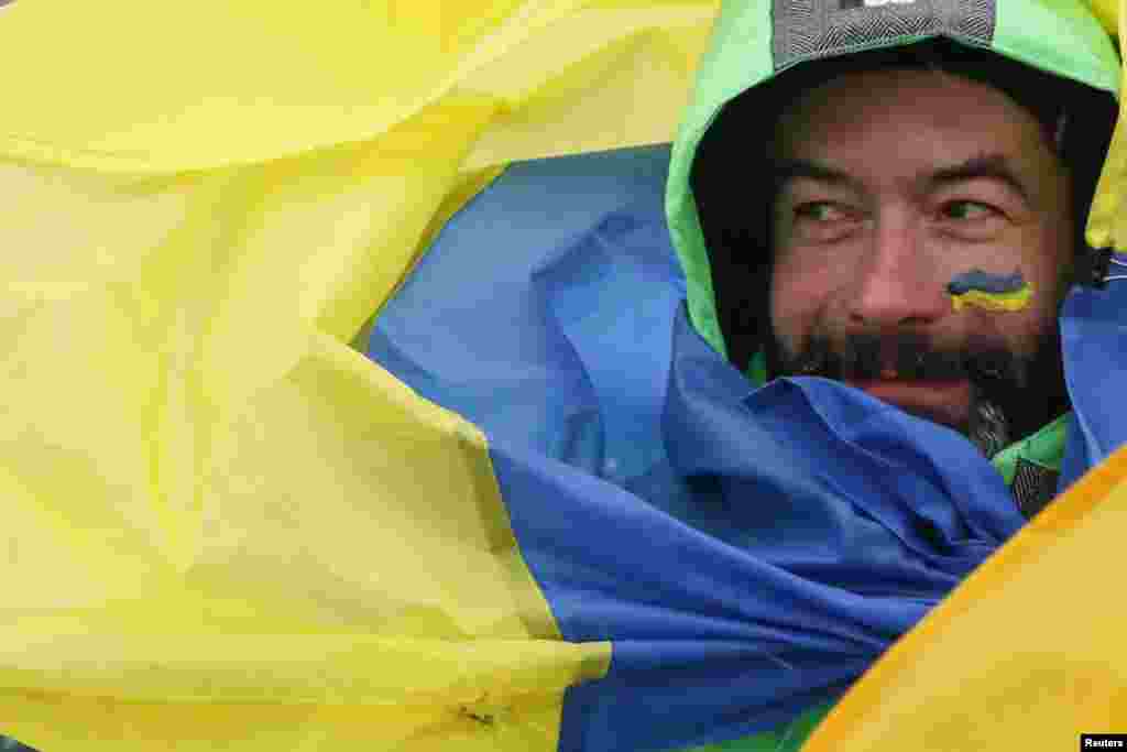 A man wrapped in a national flag takes part in celebrations for Unity Day in Kyiv on January 22. Ukraine celebrates the anniversary marking when the western and eastern parts of the country were unified to create a single state in 1919. (Reuters/Valentyn Ogirenko)