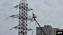 Комунальник ремонтує лінію електропередач після ракетного удару в Харкові, Україна, 6 квітня 2024 року
