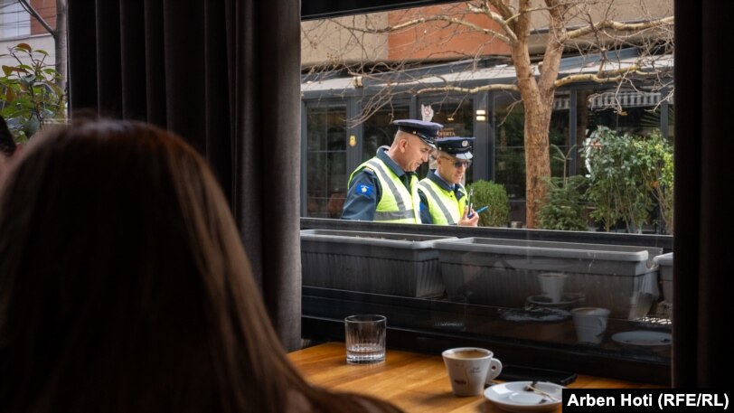 Dva policajca šetaju blizu kafića u Vučitrnu.