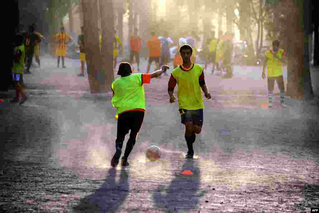 Afghan youths play soccer in a friendly match in Herat on August 11. (AFP/Aref Karimi)