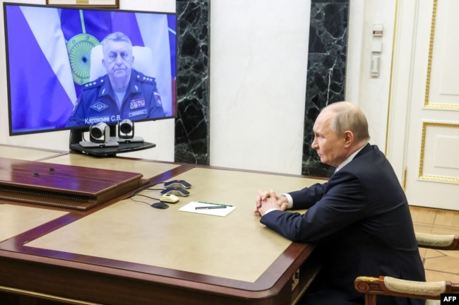 Vladimir Putin, në një vendndodhje të pazbuluar, diskuton nëpërmjet një lidhjeje video me Sergei Karakayev, komandantin e Forcave Strategjike të Raketave Ruse, testet e suksesshme të raketës balistike ndërkontinentale Sarmat, të cilat thuhet se janë kryer me sukses. 12 maj 2026