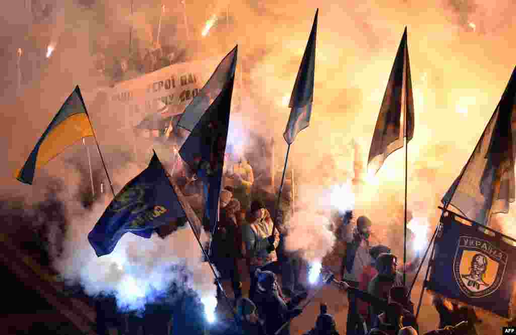 People shout slogans as they carry torches during a march organized by Svoboda (Freedom), a Ukrainian nationalist party, in Kyiv to mark the 99th anniversary of a battle near the the small Ukrainian city of Kruty. Some 300 Ukrainian students, cadets, and schoolboys were killed during combat with the regular Red Army on January 29, 1918, to protect the newly created Ukrainian People&#39;s Republic against Bolshevik aggression. (AFP/Sergei Supinsky)