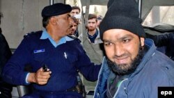 Pakistani security officials detain Mumtaz Hussain Qadri, right, one of their colleagues who allegedly killed Salman Taseer, the governor of Pakistan's most populous province of Punjab, in Islamabad in January 2011.