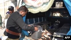 A policemen inspects the van after the attack in Quetta.