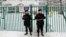Russian police officers guard the entrance to a Moscow school building after receiving a report that a student was threatening to injure himself with a knife on December 6. 