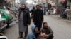 People stand outside their shops after a severe earthquake is felt in Rawalpindi, Pakistan, on January 31.