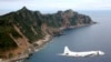 At Sea -- Japanese Maritime Self-Defense Force's PC3 surveillance plane flies around the disputed islands in the East China Sea, known as the Senkaku isles in Japan and Diaoyu in China, October 13, 2011