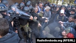 Силовик «поливає» себе зі сльозогінного балончика під час сутичок поліції та активістів під будівлею Генпрокуратури, Київ, 17 вересня 2018 року