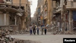 Sirijci nakon što su dobili hranu od jedne humanitarne organizacije, mart 2013.