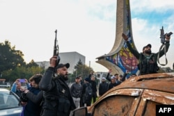 Luptătorii antiguvernamentali sărbătoresc în Piața Umayyad din Damasc pe 8 decembrie 2024. Rebelii conduși de islamiști au declarat că au cucerit Damascul.