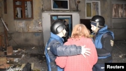 Emergency psychologists speak with a resident at the site of a Russian drone strike on the Ukrainian city of Kropyvnytskiy on March 20. 