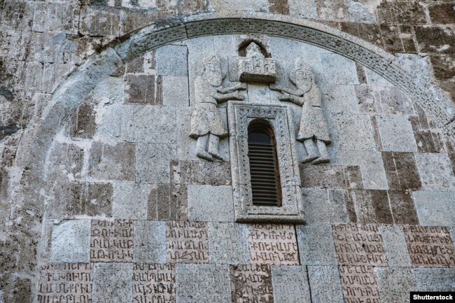 Detaje në Manastirin Dadivank me shkrim armen dhe figura të gdhendura.