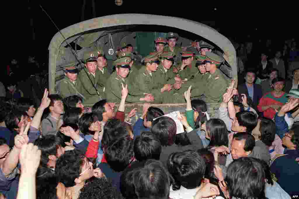 Semne de victorie. Demonstranții opresc un convoi militar în drum spre Piața Tiananmen, la scurt timp după ce legea marțială a fost declarată, pe 20 mai 1989.