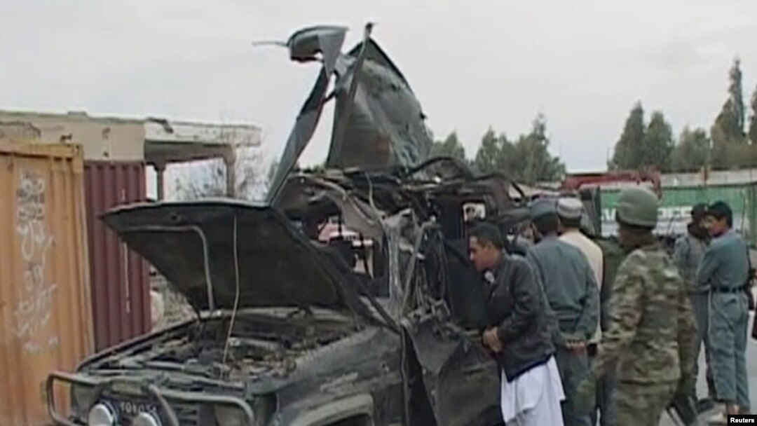 Security personnel examine the damaged vehicle belonging to Deputy Governor Abdul Latif Ashna, who was killed in the attack.