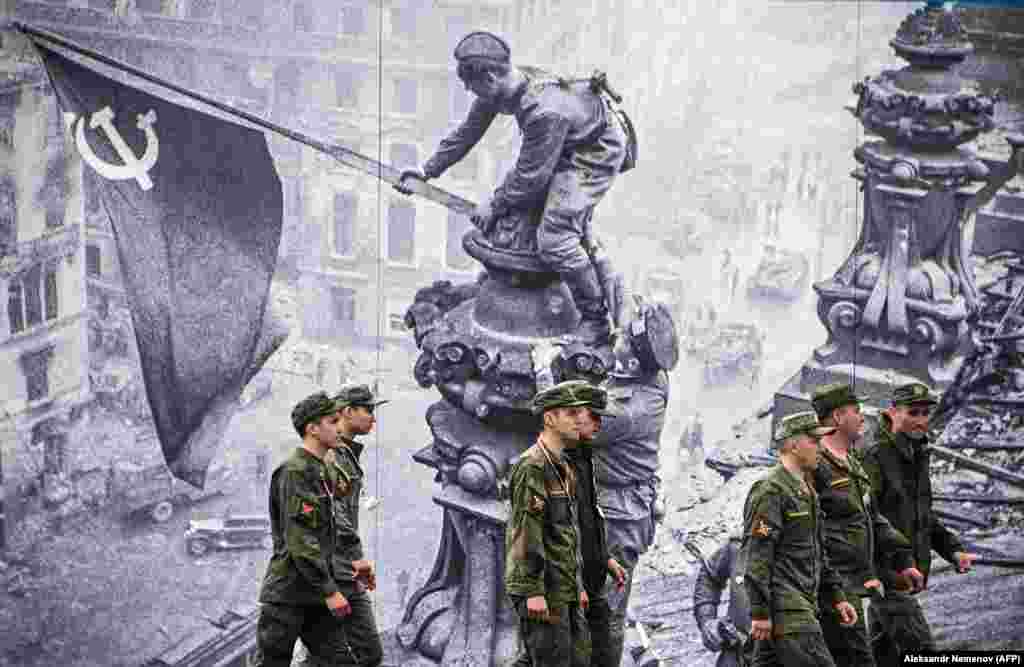 Russian Army servicemen walk past decorations on Red Square in Moscow ahead of the 76th anniversary of the victory over Nazi Germany during World War II. (AFP/Alexander Nemenov)