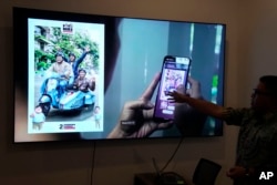 Noudhy Valdryno, koordinator digjital për ekipin e kandidatit indonezian për president Prabowo Subiantos, duke e prezantuar aplikacionin ku mbështetësit mund t’i fusin edhe fotografitë e tyre, për t’u krijuar më pas një fotografi e re, me ndihmën e inteligjencës artificiale.