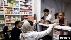 Iranians buy medicines at a pharmacy in Tehran in April. The Iranian Pharmacists Association says around 800 medicines are currently on the country's shortage list. 