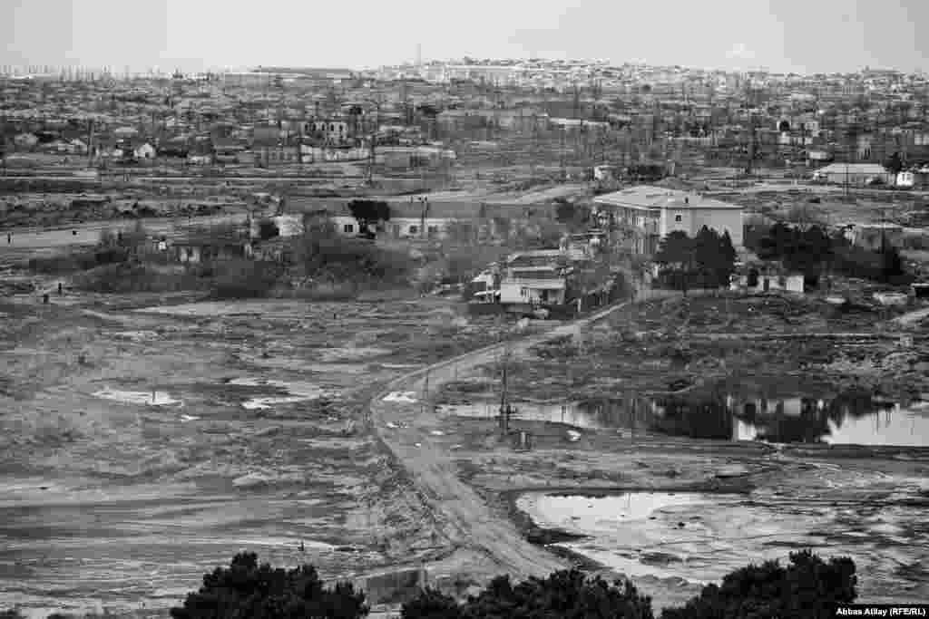 Neft gölməçələri və ətrafında tikilmiş evlər.